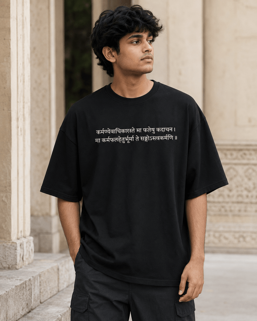 Model wearing Karma Oversized T-Shirt in black with Sanskrit shlok front chest print