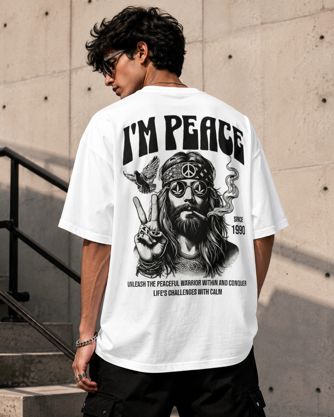 Young male model wearing the Peace Oversized T-Shirt in white, showing the bold black peace-inspired back graphic print.